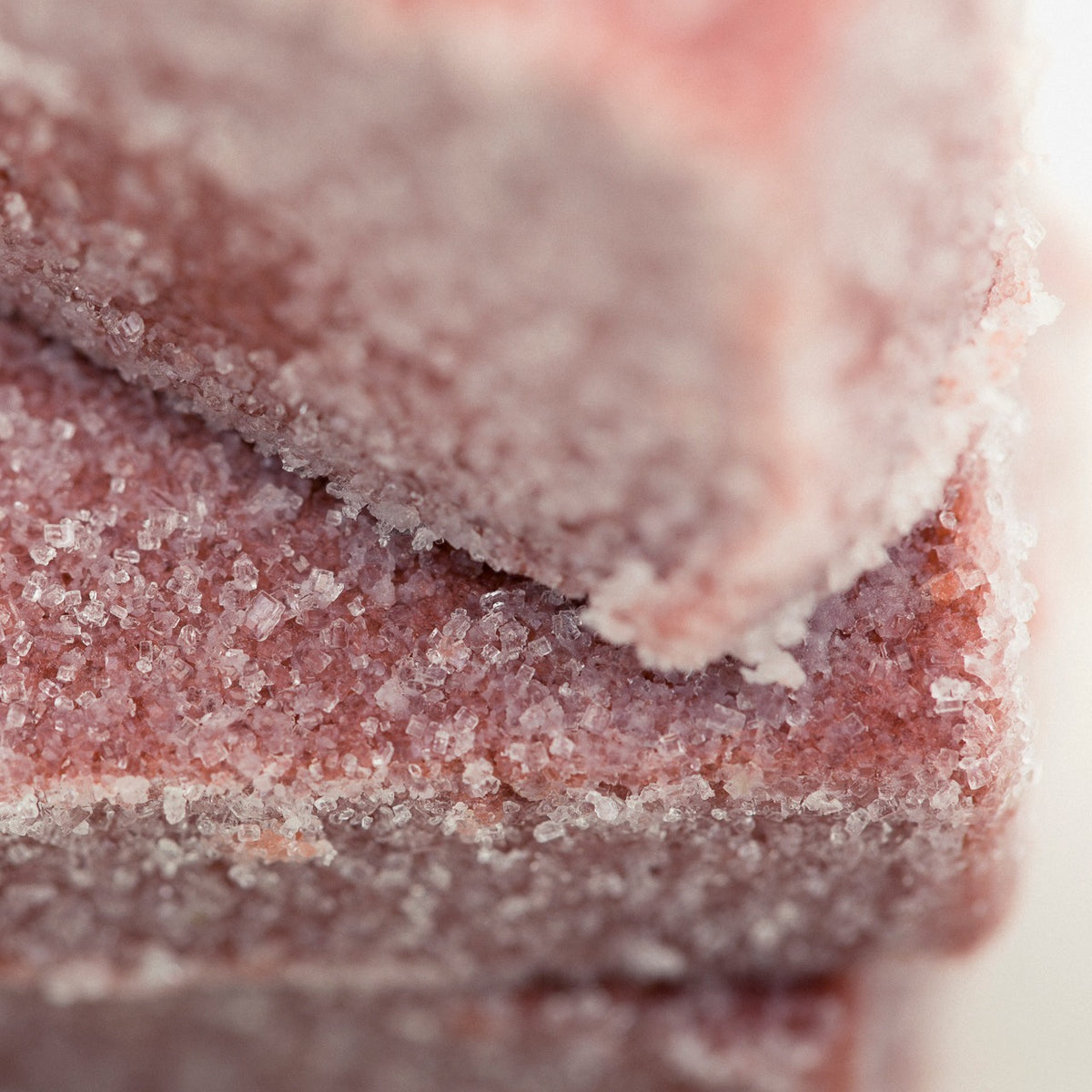 Close up of Peppermint sugar scrub cube showing it's delicate rose color and sugary texture